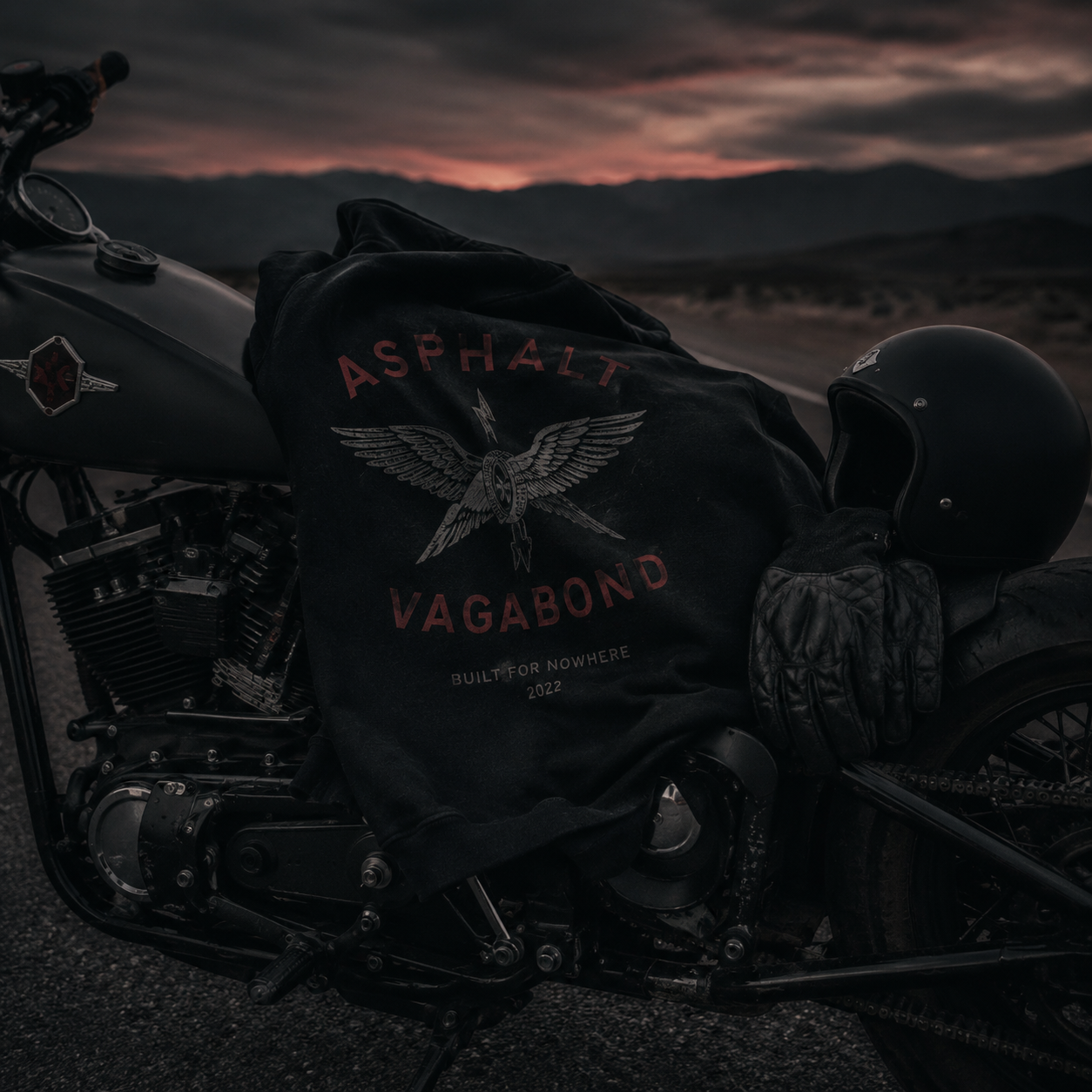 Asphalt Vagabond hoodie, gloves, and helmet styled on a custom motorcycle at dusk
